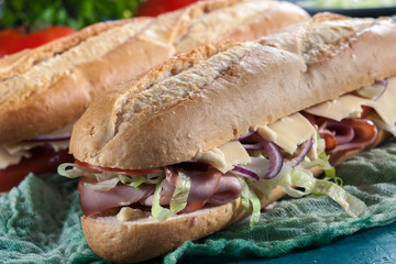 Submarine sandwiches with ham, cheese and vegetables