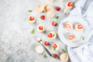 Summer sweet homemade dessert, Mini cheesecakes with strawberry on grey stone table copy space top view