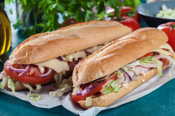Submarine sandwiches with ham, cheese and vegetables