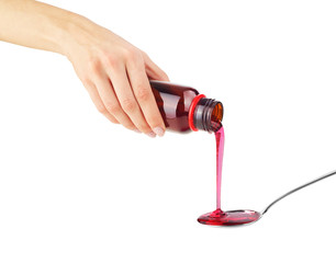 hand holds a spoon with syrup