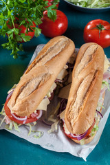 Submarine sandwiches with ham, cheese and vegetables