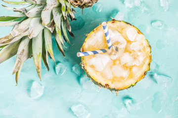 Summer refreshment drink concept, tropical pineapple cocktail or juice in pineapple with ice, light...