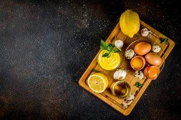 Homemade mayonnaise sauce with ingredients - lemon, eggs, olive oil, spices and herbs, black...
