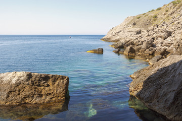 Large stones stick out of the water and are visible at the bottom of the sea.Mountain coast of Crimea.