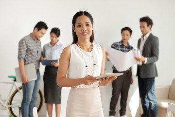 Obraz premium Portrait of Asian smiling businesswoman using digital tablet for work