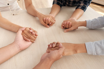 Close-up of group of people supporting each other. They are holding hands