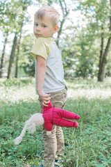 Loneliness, depression, sadness of the child. An old doll in the hands of a child.