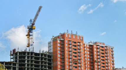 Fototapeta na wymiar Concrete buildings under construction. Crane near building. Construction site.
