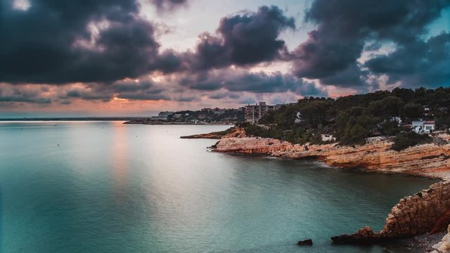 Sunset on the Mediterranean Sea. Beautiful rock formations on the beach of Spain. Sea bay. The resort town of Salou. Coast of Costa Daurada. The province of Tarragona. La Pineda. Catalonia.