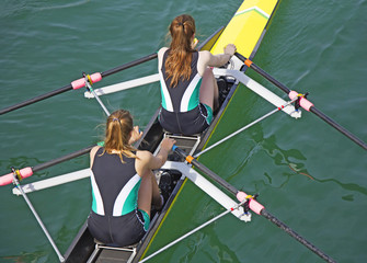 Two young women rowing race in lake