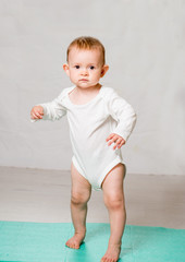 the baby is performing physical exercises on the yoga mat. Baby Yoga