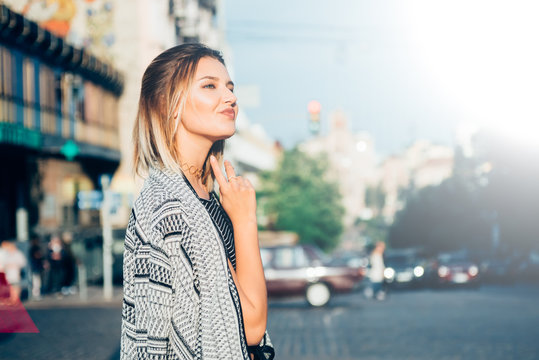 Beautiful and gorgeus blonde girl walking in an urban contest, srong personaliies and self esteem attitude,dreaming pose, natural light, flare.