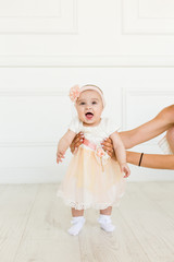 Little fairy. sweet ballerina with fluffy peach skirt and flower. Cute smiling baby girl on white studio backgroung. 6 months baby