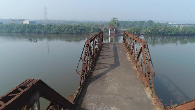 Aerial view. Flying over rusty truss of the demolished bridge over the river Zuari in Goa, India.