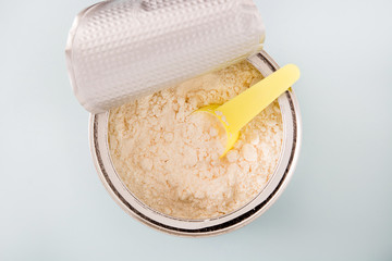 powder milk in the bottle on gray background. Top view