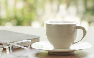 Cup Of Coffee And Eyeglasses With Book On Table In Morning.