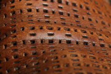 Natural old brown leather with perforation in form of the rectangles. Abstract background