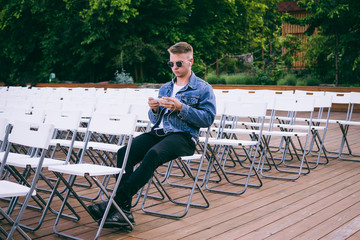 Handsome young hipster man using smartphone outdoors in park