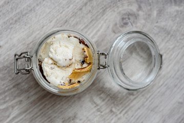 Homemade ice cream in a glass jar on a wooden background