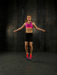 Young woman exercising with fitness jumping rope