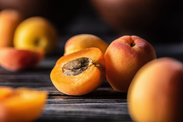 selective focus of ripe apricots on wooden table - obrazy, fototapety, plakaty