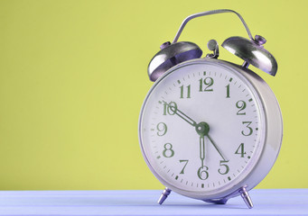 Retro alarm clock on a pastel background, copy space.