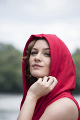 Lovely model is posing on wooden pier at riverside.Outdoor fashion conception. 