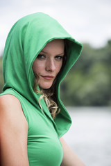 Lovely model is relaxing on wooden pier at riverside. Outdoor fashion conception.