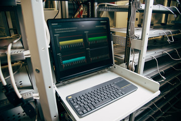 monitor showing bitcoin data in a farm with wires