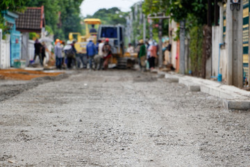 Many workers build asphalt roads. Gradient Blur.