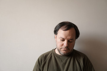 depressed man in his forties leaning against wall with copy space. depression or midlife crisis...