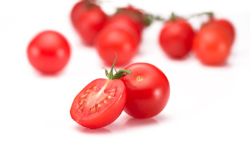 close up view of fresh cherry tomatoes on twig isolated on white
