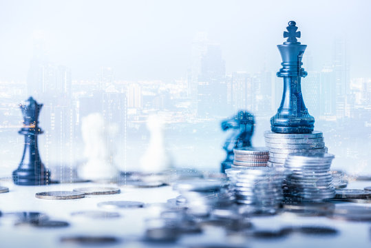 double exposure image of the coin stack which has the Staunton chess set such as king on top and overlay with cityscape image. the concept of accounting, business, financial, economy and investment.