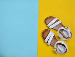 Fashionable leather women's sandals on a colored pastel background, summer shoes, top view,...