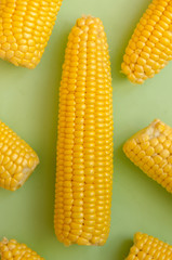 Bright ripe yellow corn on a green background in the style of pop art.