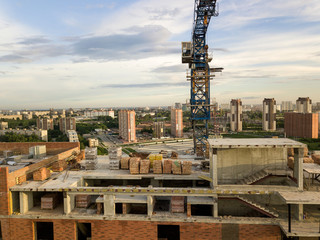 Aerial view of a new modern house under construction with a blue tower crane
