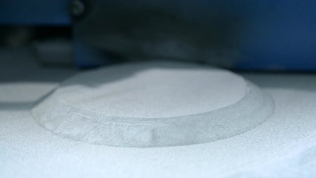 Raising up printing platform with object printed on 3d printer for metal and covered metallic powder. 3D printer printing metal. Laser sintering machine for metal Progressive DMLS, SLM, SLS technology