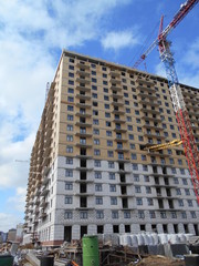 Fototapeta premium Construction of a multi-apartment residential building. The process of construction. Stages of construction.