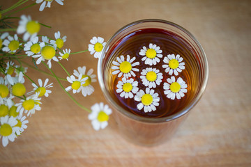 chamomile tea in a cup. tea with chamomile in a glass on a wooden background