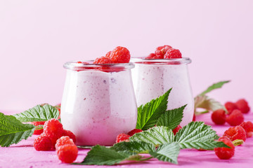 Raspberry smoothie with berry and yogurt on pink background, selective focus