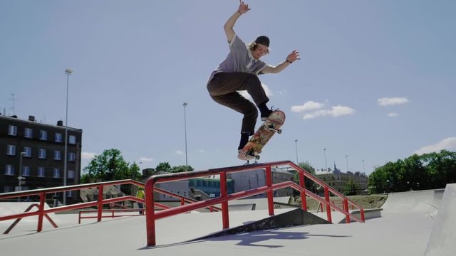 Young skater doing tricks outdoors. Slowmotion video 150fps