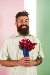 Flowers delivery concept. Man with beard cheerful face holds bouquet fresh flowers. Guy holds bouquet confident about date. Delivery man with flowers. Hipster with beard ready holiday congratulate