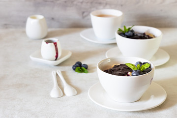 Obraz na płótnie Canvas Porridge with blueberry sauce decorated fresh blueberries and mint. 