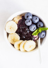 Porridge in a bowl with blueberries, banana and mint. Healthy breakfast concept