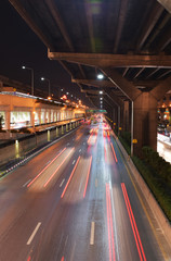 Fototapeta na wymiar The light motion of car on road under tollway in the night at Bangkok, Thailand