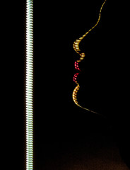 Sensual female profile in the dark, close up, studio shot