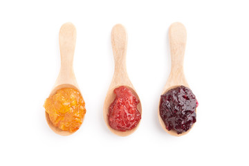 Strawberry, orange and blueberries jam with wooden spoon on a white background. top view.
