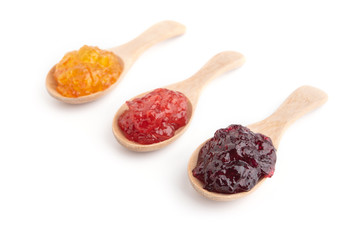 Strawberry, orange and blueberries jam with wooden spoon on a white background