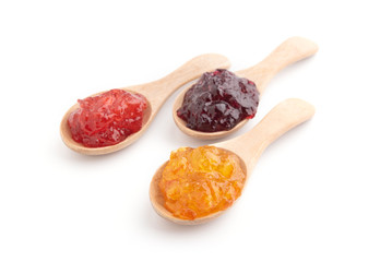 Strawberry, orange and blueberries jam with wooden spoon on a white background