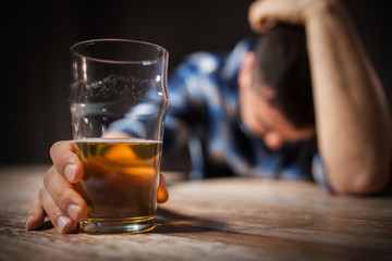 alcoholism, alcohol addiction and people concept - male alcoholic with glass of beer lying or...